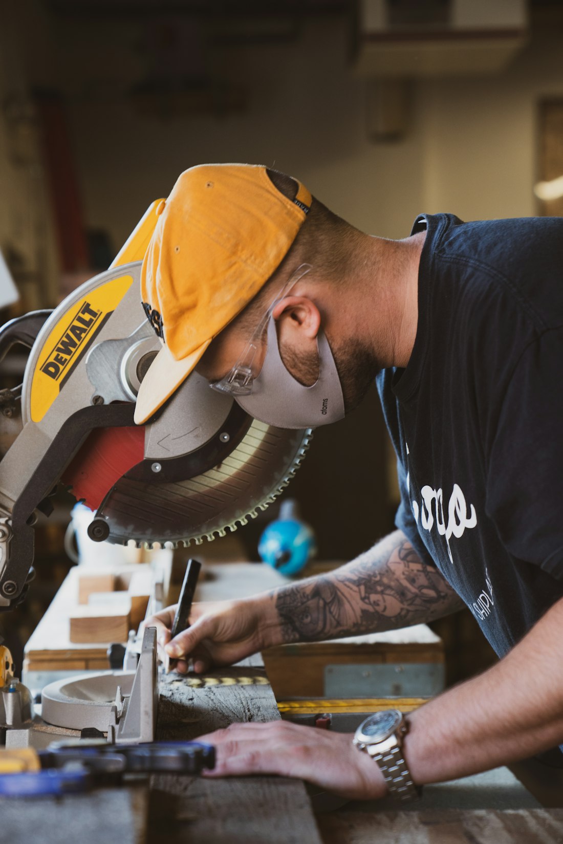 A joiner planing a length of hardwood at the workbench in a sunlit workshop